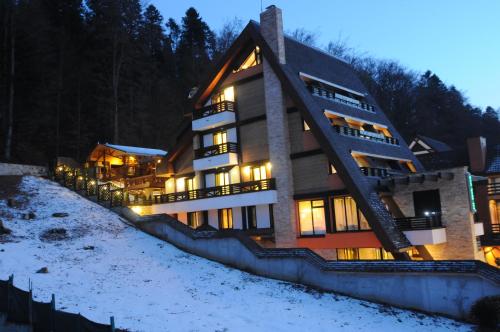 a large building in the snow at night at Casa Freya in Buşteni