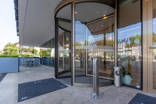 ein Glasgebäude mit Parkuhr davor in der Unterkunft Sea Porto Hotel in Matosinhos