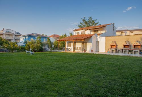 a house with a green lawn in front of it at Nicole Fresh Apartments in Keramotí