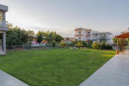 a yard with a green lawn with houses at Nicole Fresh Apartments in Keramotí