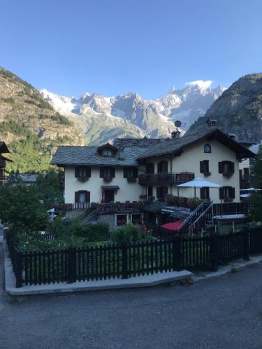 een huis met een hek voor een berg bij Maison Laurent in Courmayeur