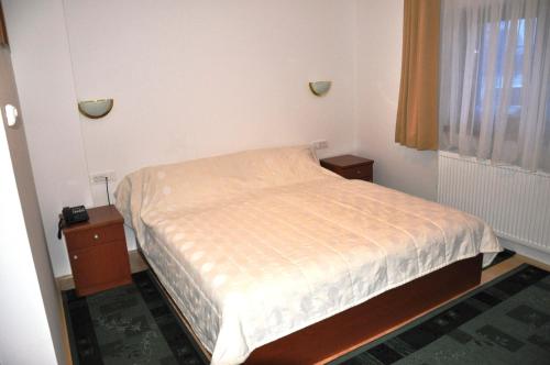 a small bedroom with a bed and a window at Penzion Kmečki Hram in Ljubljana