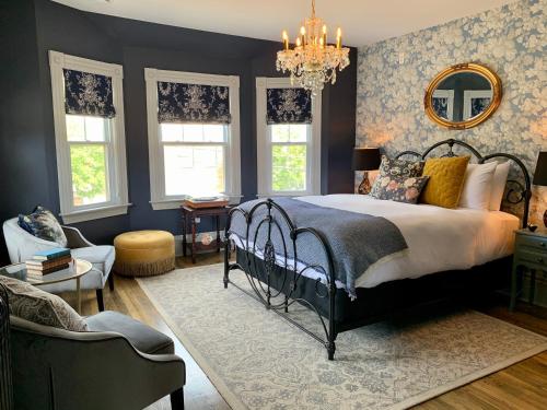 una camera con letto e lampadario a braccio di Slaymaker & Nichols Gastro House & Inn a Charlottetown