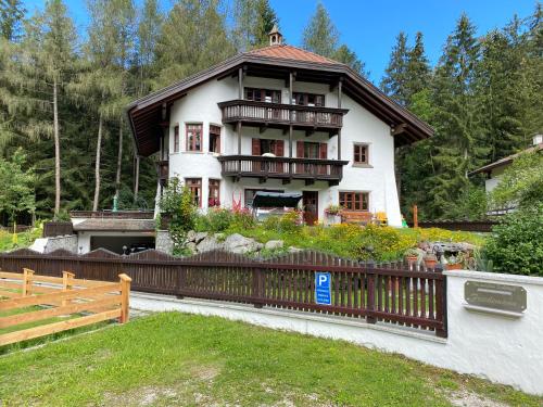 uma casa grande com uma cerca em frente em Im weißen Schlössl Friedemann em Rasùn di Sotto