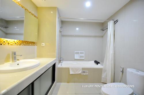 een badkamer met een wastafel, een toilet en een douche bij Kasira Residence in Jakarta