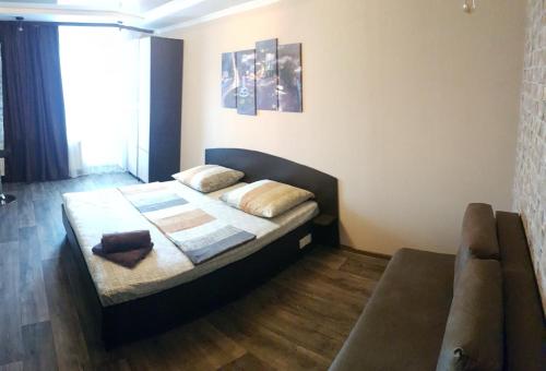 um quarto com uma cama e um sofá em Apartment new 95 Kvartal em Kryvyi Rih