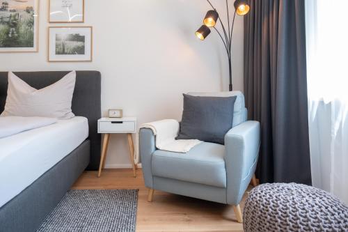 ein Schlafzimmer mit einem blauen Stuhl und einem Bett in der Unterkunft MH Living - 5 - Scandinavian Living Dream in Center in Graz