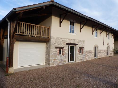 una casa con due porte garage e un balcone di Gites Domaine de la Rochere a Domsure