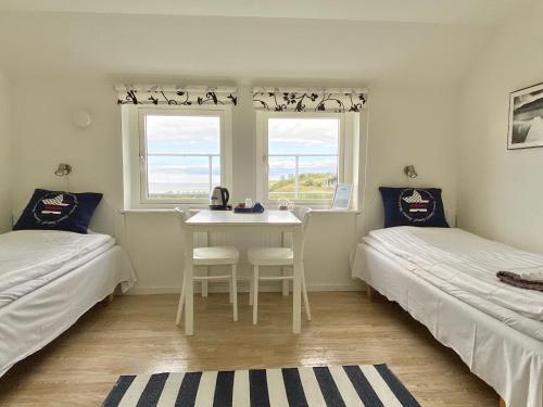 a room with two beds and a table and a window at Löderup Strandbad Hotell och Restaurang in Löderup