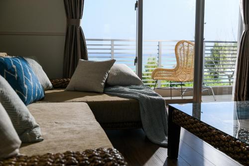 a living room with a couch and a balcony at Odysis Onna Resort Hotel in Onna