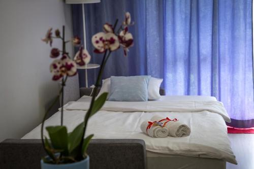 een slaapkamer met een bed met witte lakens en bloemen bij Dream Apartment in Suwałki