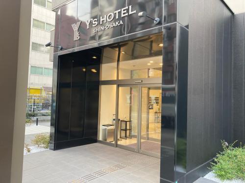 un edificio con un cartel en el costado en Y's HOTEL Shin Osaka, en Osaka