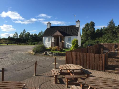 een huis met een picknicktafel en een hek bij The Shandwick Inn in Tain