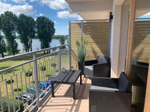 einen Balkon mit Stühlen und Blick auf das Wasser in der Unterkunft Marina Green Loft-Apartament przy promenadzie in Lyck