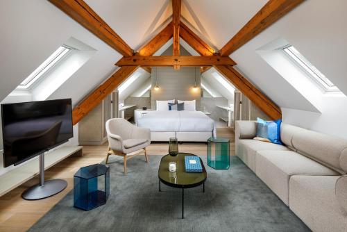 een slaapkamer op zolder met een bed en een bank bij Hotel Felix in Zürich