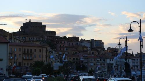 una città con auto parcheggiate in una strada con edifici di La casa di Elba e Mario a Porto Santo Stefano