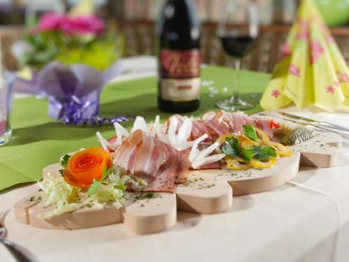 un plato de comida en una mesa con una botella de vino en Berghotel Türlwand, en Ramsau am Dachstein