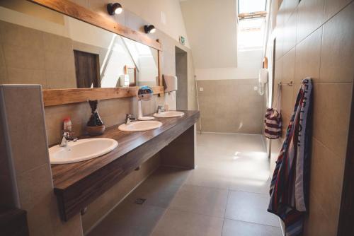 a bathroom with two sinks and a large mirror at Camp Podgrad Vransko in Vransko