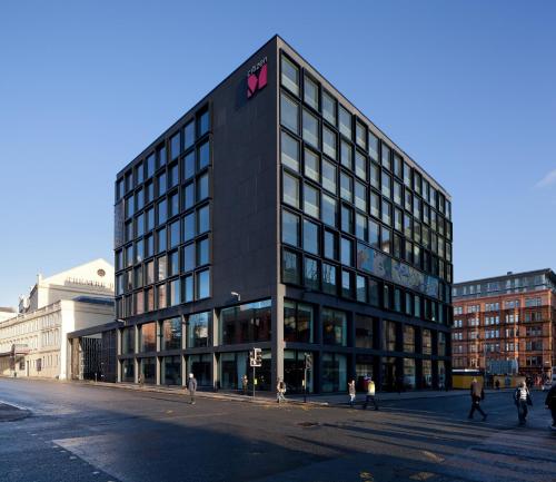 ein großes schwarzes Gebäude mit einem Schild an der Seite in der Unterkunft citizenM Glasgow in Glasgow