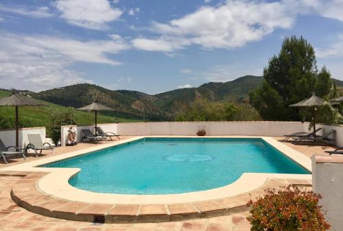 een zwembad met bergen op de achtergrond bij Cortijo Valverde Alora in Alora