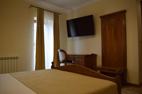 a bedroom with a bed and a desk and a television at Vila Preciosa in Alba Iulia