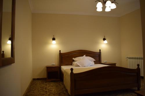 a bedroom with a bed with white pillows on it at Vila Preciosa in Alba Iulia