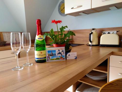 uma garrafa de champanhe e duas taças de vinho no balcão em Lavendelblume - 4 Sterne inklusive Power WLAN - Wäschepaket - BikeBox - Parkplatz # Bestpreisgarantie # em Zingst