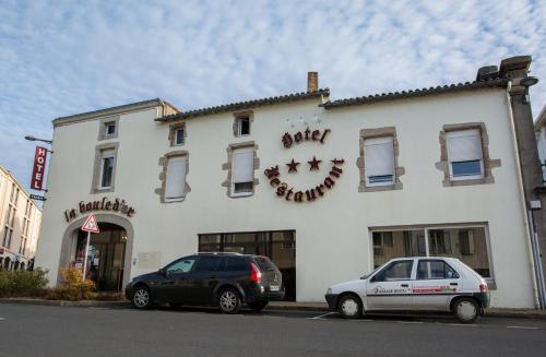 zwei Autos, die vor einem weißen Gebäude geparkt sind in der Unterkunft La Boule d'Or in Bressuire