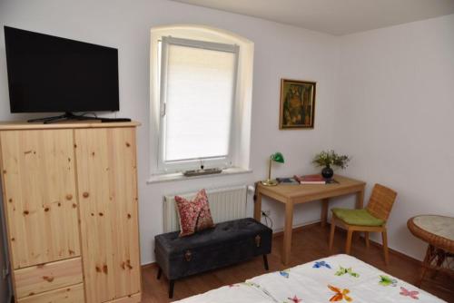 1 dormitorio con 1 cama, TV y mesa en Ferienwohnung Zentrum, en Neuruppin