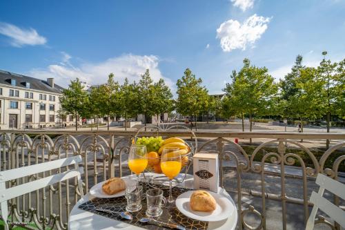 - une table avec des verres de jus d'orange et de pain dans l'établissement L'île de la Brèche, à Niort