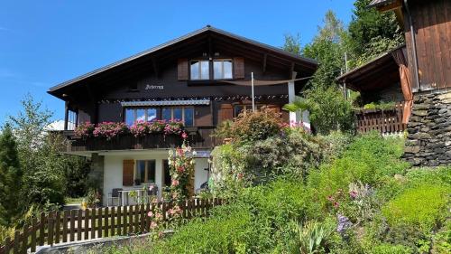 una casa con una recinzione e dei fiori di fronte di Chalet Acheregg a Wengen