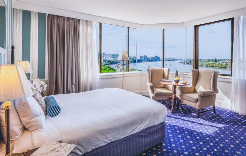 una camera d'albergo con letto, tavolo e sedie di View Brisbane a Brisbane