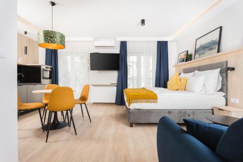 een slaapkamer met een bed en een tafel en stoelen bij InPoint Apartments G11 near Old Town & Kazimierz District & Parking Option in Krakau