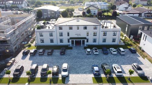 una vista aerea di un grande edificio bianco con auto parcheggiate di Hotel Sleep & Dream Nähe Europa Park und Rulantica a Ringsheim