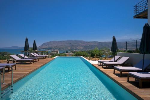 una piscina con sedie a sdraio e ombrelloni presso un resort di Seametry Apartments a Souda (Suda)