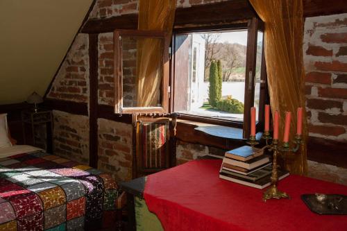 a bedroom with a bed and a table with books at Baltā māja in Pilsrundāle