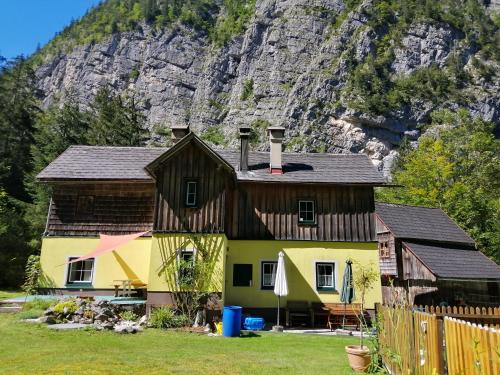 une maison en face d'une montagne dans l'établissement Haus Waldbach, à Hallstatt