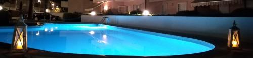 a large swimming pool with blue lights on a building at B&C Apartments in Lido di Jesolo