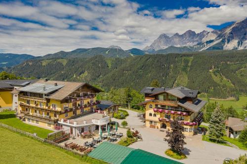 une vue aérienne sur une maison avec des montagnes en arrière-plan dans l'établissement Der Burgfellnerhof - Adults Only, à Schladming