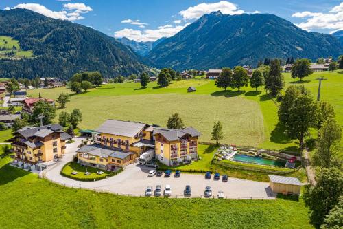 - une vue aérienne sur un complexe avec piscine et montagnes dans l'établissement Der Burgfellnerhof - Adults Only, à Schladming