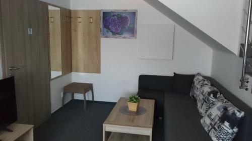 uma sala de estar com um sofá e uma mesa em Penzion Kometa em Pasohlávky