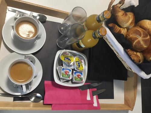 un tavolo con due tazze di caffè e un piatto di cibo di V E R O N E - Rooms & Suites - Liège - Rocourt a Liegi