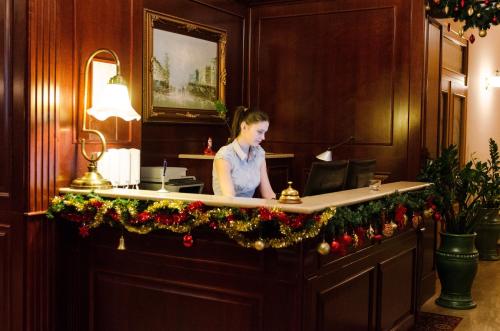 une femme est assise sur un bureau avec un microphone dans l'établissement Hotel Dorottya, à Kaposvár