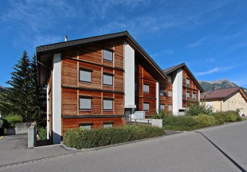 aartment building with a wood facade on a street w obiekcie Tgesa La Niva 1 w mieście Savognin