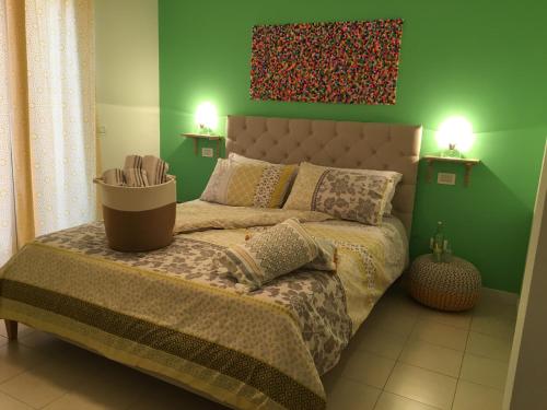 1 dormitorio con 1 cama con pared verde en Intra Rooms, en Olbia