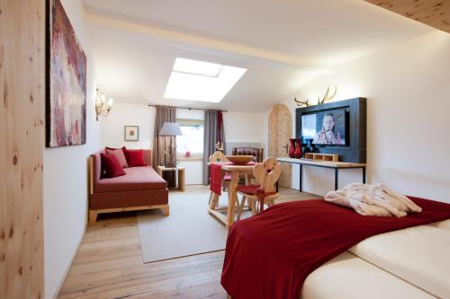 - une chambre avec un lit et un salon dans l'établissement Minglers Sportalm - Das Gourmet- und Genießerhotel, à Kirchberg in Tirol