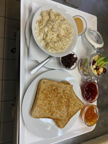 - une assiette de nourriture avec un bol de flocons d'avoine et de pain grillé dans l'établissement Western-Inn, à Klipphausen