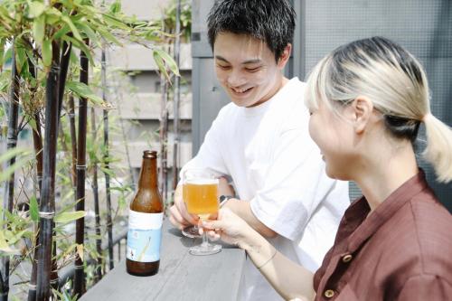 高松市にあるSUNNY DAY HOSTELの男女一杯のビール