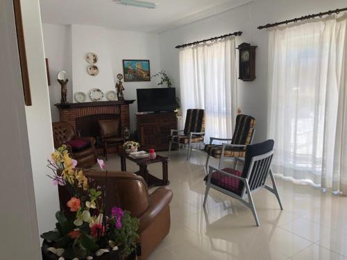 ein Wohnzimmer mit einem Sofa, Stühlen und einem TV in der Unterkunft Residencia Maria Jose in Fátima