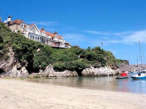 una casa su una collina con barche in acqua di Harbour Hotel a Newquay